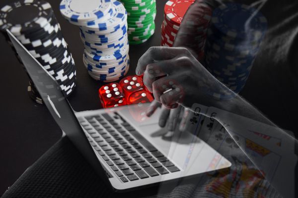 Man playing Online Live Casino on a laptop with casino chips